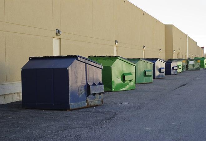 a construction worker disposing of debris into a dumpster in Burton MI